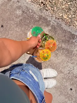 A carrier of four iced drinks topped with paper umbrellas